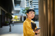 © Davor - Thoughtful businesswoman holding smartphone in modern city