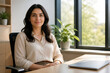 © nibelheim - Professional woman sitting at modern office desk, smiling at camera, taking mindful work break
