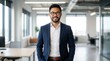 © Panpatsa - Successful Asian male professional posing in a modern office with a confident smile.