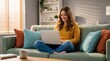 © Eka - Smiling young woman working remotely on laptop from a comfortable living room couch, embracing a modern, flexible digital lifestyle