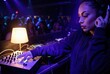 © Leo Rohmann - Nightclub DJ mixing tracks with headphones and purple stage lights