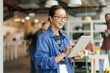 © BusinessClass by W61 - Smiling businesswoman uses a tablet in a modern coworking office
