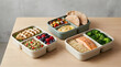 © Maira - Three plastic meal prep containers with balanced healthy food.
