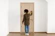 © Prostock-studio - Unrecognizable Black Female Knocking On Door, Standing In Casual Outfit. Focused On Invitation At Home Setting, Waiting For Response With Anticipation. Indoor Atmosphere Reflecting Home Concept.