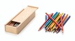 © Maicon - A light wooden pencil box with a sliding lid partially open, revealing a few pencils inside, is placed next to a colorful pile of sharpened pencils on a white background.