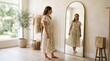 © Azor - Woman in floral dress trying on clothes in front of a large mirror in a bright room with plants and clothing rack