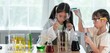 © BESTIMAGE - Two child girls enjoying science experiment with colorful liquids in laboratory learning curiosity education. Young students wearing goggles and lab coat having fun with test tubes in classroom.