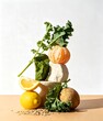 © ersya - Artistic food stack with citrus fruits leafy kale and grains on stone pedestals for healthy lifestyle concept