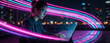 © Viktor - Focused young woman works on laptop computer with colorful neon light trails at night. Female freelancer uses digital tech in modern urban office. Creative pro programmer types on keyboard amidst