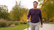 © Vyatcheslav - Man walking with a cane in an autumn park. Middle aged male recovering from injury strolling outdoors. Mobility and rehabilitation concept