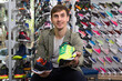 © caftor - Customer proudly presenting chosen sneaker in sports store
