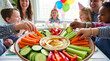 © val_webart - Happy children enjoying vegetable platter with hummus at a party