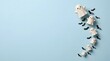 © ASHRAF - Halloween background photo with cute ceramic ghosts and bats arranged on a light blue pastel surface with copy space