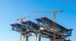 © Sourithideth - Large scale bridge construction site featuring steel girders and heavy cranes under a clear sky symbolizing economic growth and progress, development, development, bridge