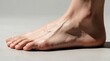 © miss irine - Close up of a human foot side view with prominent veins and detailed skin texture. Barefoot on a neutral surface, highlighting foot anatomy and health.