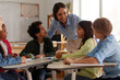 © Home-stock - Female teacher interacting with group of primary school students during classroom activity