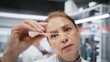 © DC Studio - Materials scientist inspects a thin glass slide for structural defects or impurities, performing visual quality control with a compound microscope.