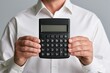 © Generative AI - Businessman holding black calculator against gray background