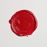 Round glossy red wax seal on white background