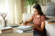 © PheelingsMedia - Telecommuter signing contract or filling form working at home