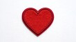 © grafyloft - Close up of a red embroidered heart patch on a white background for valentines day concepts