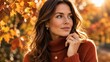 © Alex Shrb - Beautiful young woman with long wavy brown hair in terracotta turtleneck sweater posing among autumn leaves in golden sunlight