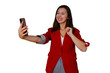 © Komora - Woman in a red blazer smiling and taking a selfie with her smartphone, enjoying social media communication. Transparent background
