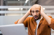 © Tetiana - Young man reacting to shocking news on laptop
