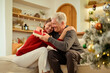 © tonefotografia - Dad and Daughter Share a Gift Moment During the Holiday Season in a Cozy Living Room