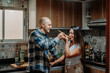 © LuisPimenttel - A couple cooking together in a cozy home kitchen, sharing food and enjoying a relaxed moment of companionship and connection.