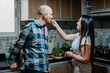 © LuisPimenttel - Woman playfully feeding her partner in the kitchen during a relaxed cooking moment, expressing affection, intimacy and a close relationship.