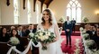 © Bunlong - A bride walking down the aisle in a church with a white and green bouquet.