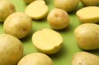 © New Africa - Ripe raw young potatoes on green background, closeup