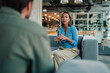 © Zamrznuti tonovi - Woman actively discussing and collaborating with a colleague in a modern office lounge area, sharing ideas and expertise