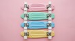 © Abu - Row of four pastel colored plastic cruiser skateboards in pink, mint green, sky blue, and yellow arranged neatly on a soft pink background, flat lay top view, minimalist retro aesthetic