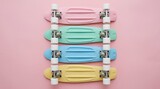 Row of four pastel colored plastic cruiser skateboards in pink, mint green, sky blue, and yellow arranged neatly on a soft pink background, flat lay top view, minimalist retro aesthetic