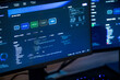 © ultramansk - A detailed view of monitoring software running on a bright desktop monitor records fingers hovering over illuminated keys during a night shift inside a modern digital office