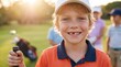 © Volha - Smiling young boy enjoying outdoor junior golf lessons with friends on a sunny day