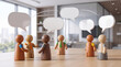 © Lutfiah - Toy wooden people figures in a meeting, discussing ideas with speech bubbles, representing teamwork and communication in a modern office setting