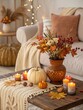 © Anastasiia - Cozy fall decor in the living room with pumpkins, candles, and a bouquet of yellow maple leaves