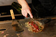 © Tororio Stock - Chef cooking meat on a hot plancha grill