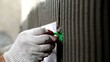 © Ruslan - Close up of tiler's hand in protective glove placing green leveling spacer into grooved cement adhesive