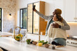 © Wavebreak Media - African American couple in loungewear hugging, posing for selfie at kitchen island with phone