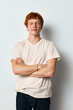 © SHOTPRIME STUDIO - Young man with red hair standing with arms crossed wearing white t shirt and jeans against white background looking confident and relaxed in casual style portrait.