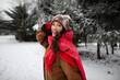 © Home-stock - Happy young woman wrapped in vibrant red scarf posing in snowy forest