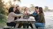 © Marin Studio - Friends enjoying a celebratory toast at a picnic table by the beach