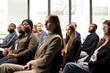 © DC Studio - Multiethnic participants listen to a business speech during a convention meeting, attending an international summit for development and networking; the mixed-age audience sits in a conference hall.