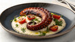 © IMRAN - Grilled octopus tentacle on creamy puree with cherry tomatoes on a dark plate