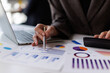 © David - Business professional analyzing financial data and statistics using a calculator and laptop, working on budget reports and market analysis with charts and graphs