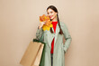 © Oleg Gekman - Autumn portrait of beautiful happy young woman with shopping bag, stylish girl holding yellow maple leaves in round hat, coat on beige studio background